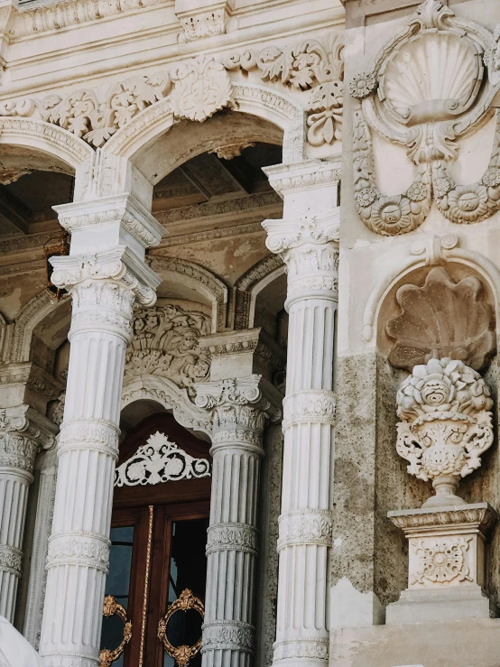 two stone columns stand in front of an ornate building