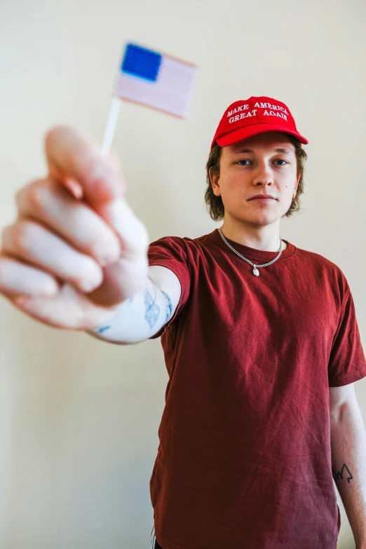 a person pointing at a tiny flag with a fist