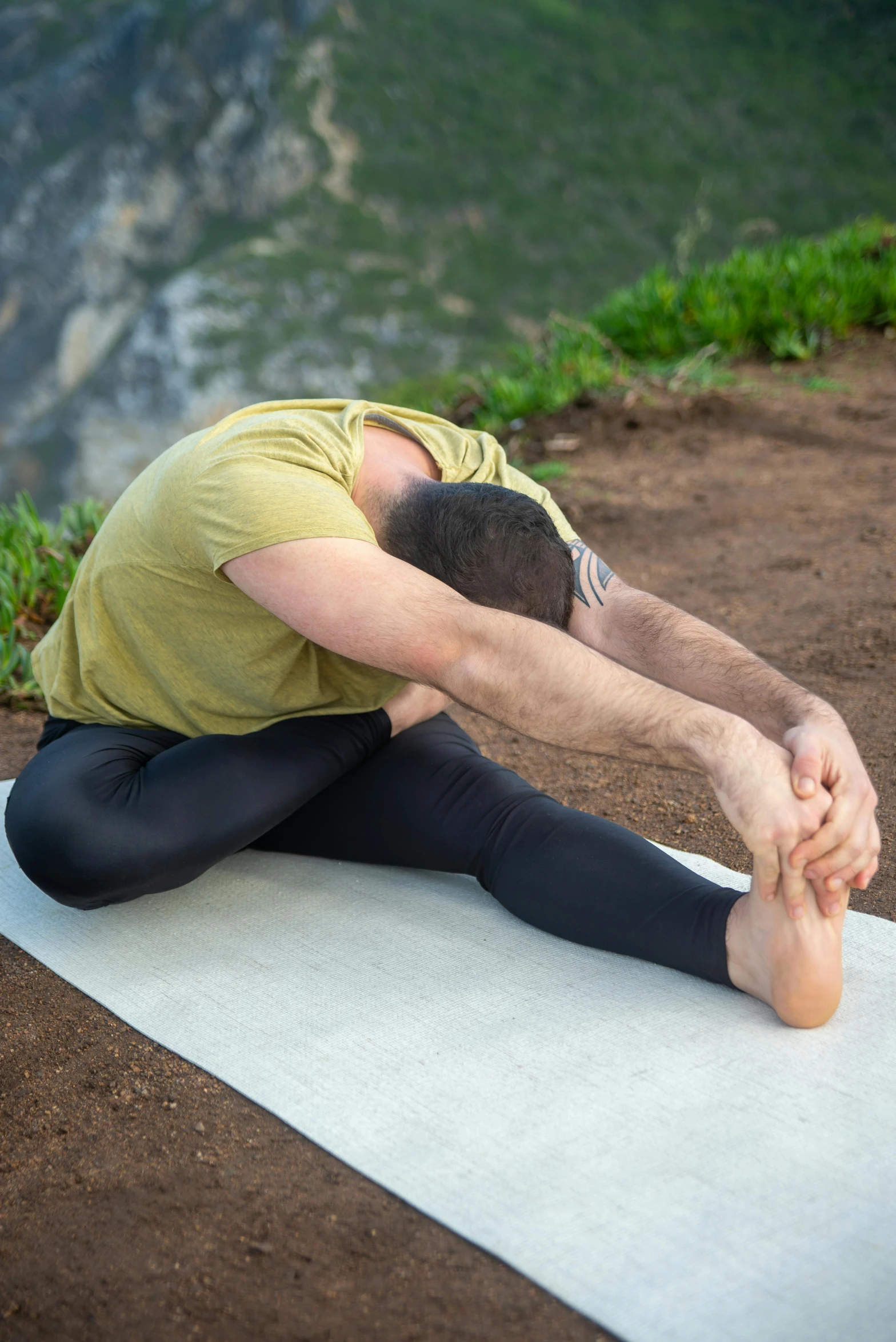 man doing yoga with mountains in the background