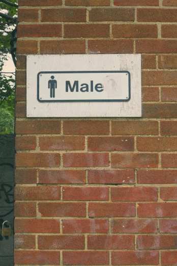 a brick wall with an arrow pointing to the male