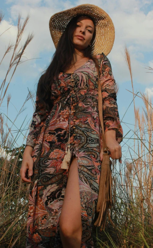 a woman with a large hat is walking on the grass