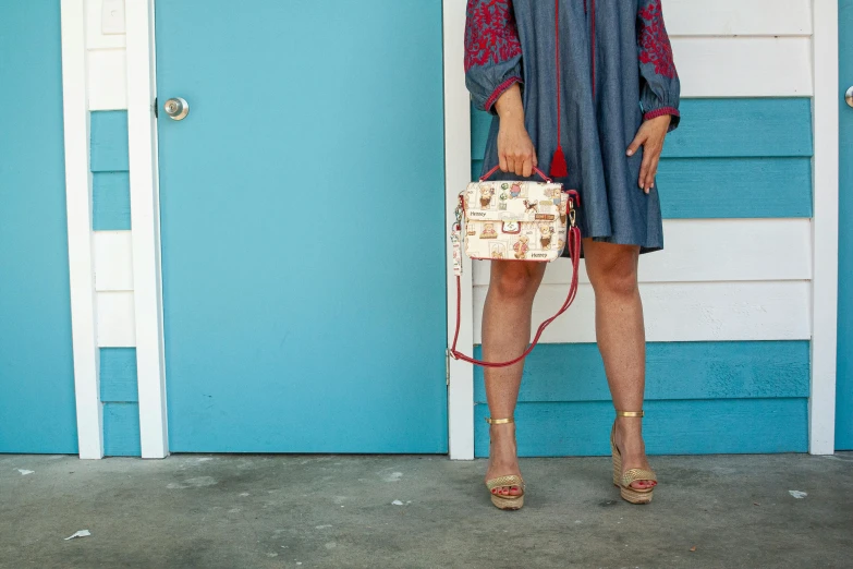 a woman in a short dress holding a small handbag