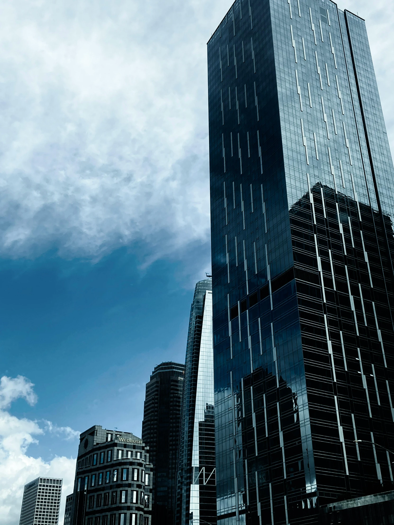 the top of several very tall buildings under a blue sky