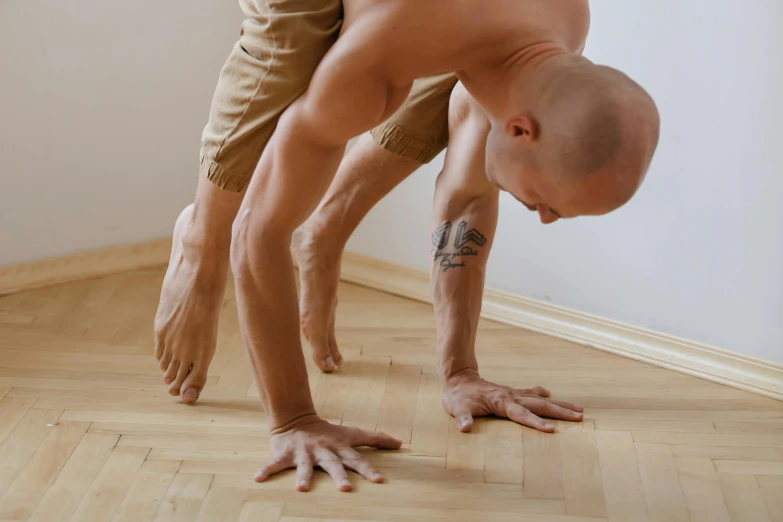 a man is bent over while performing a handstand move