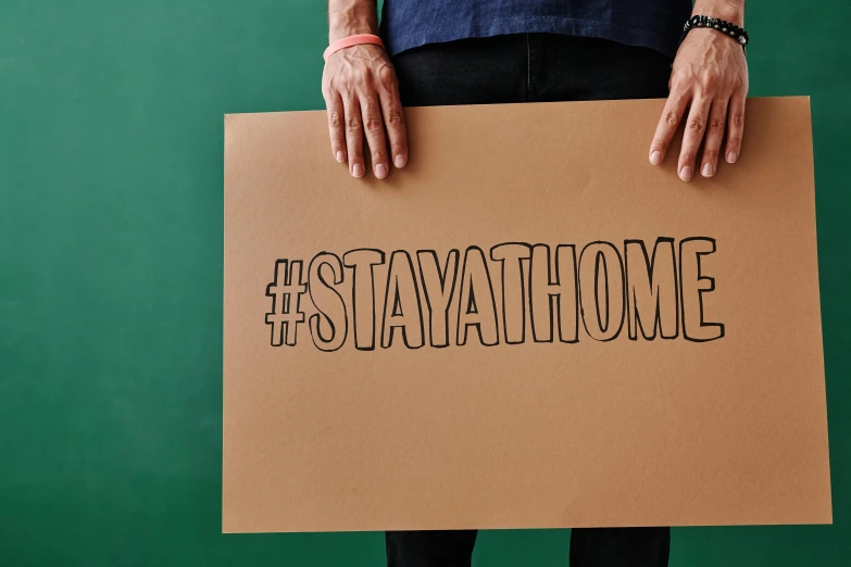 person holding up sign while standing with his legs crossed