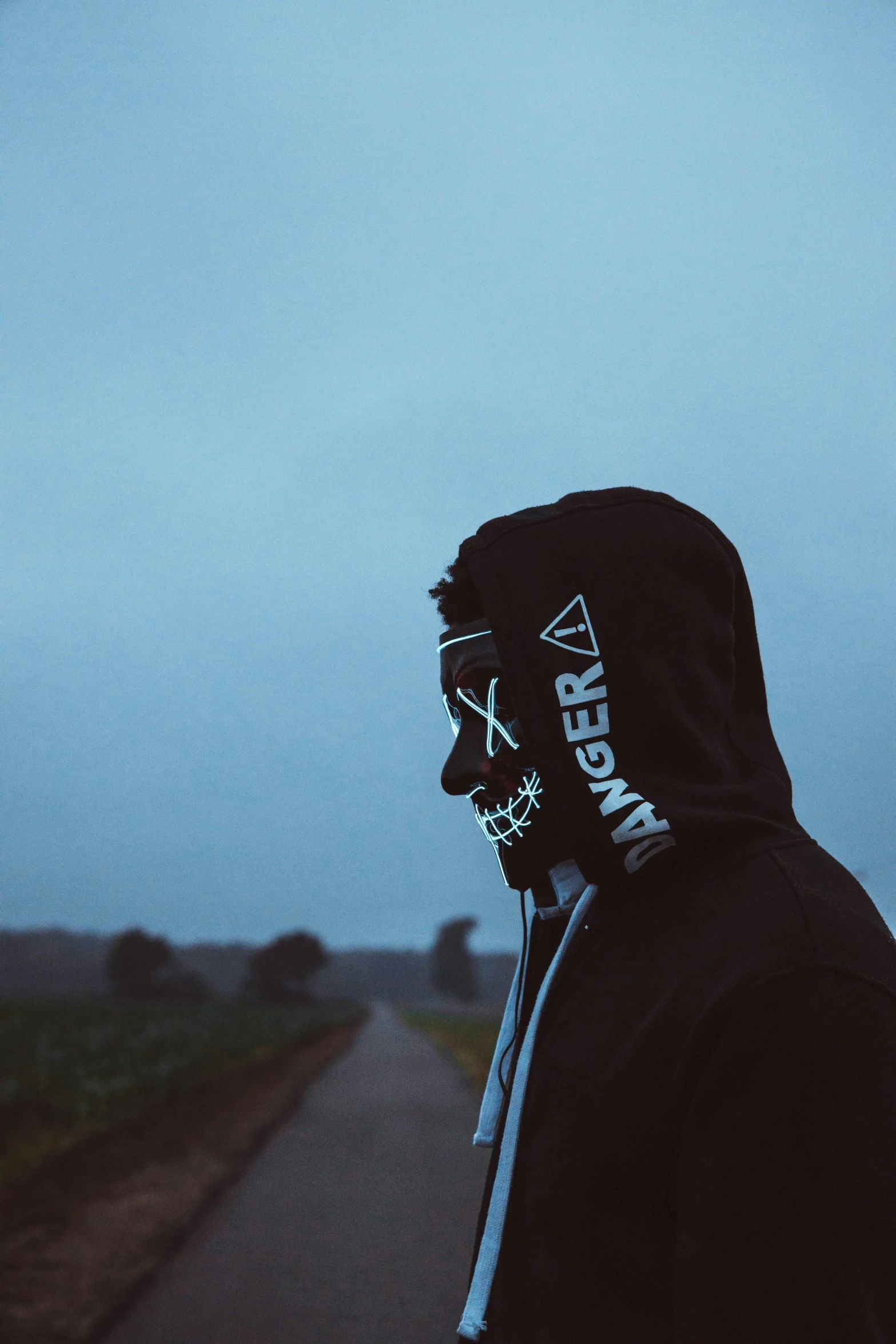 a man wearing a face mask stands on a road