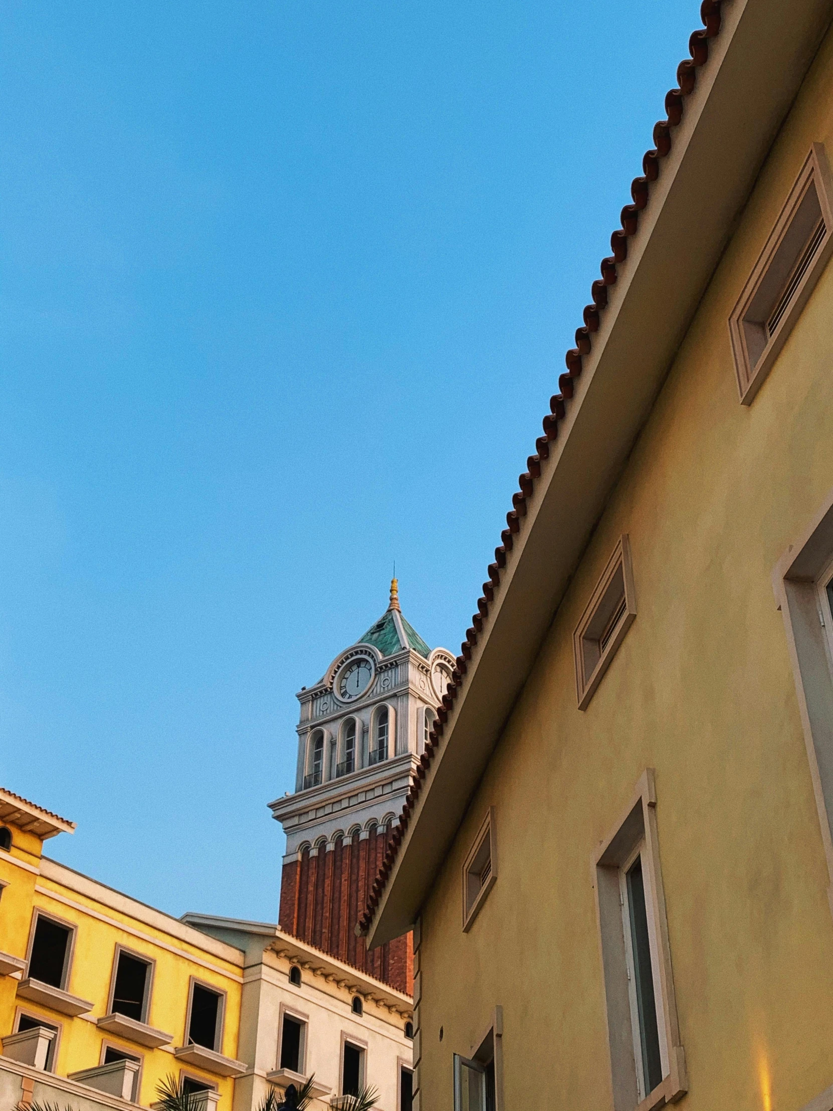 the view of a church spire from between buildings