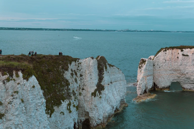 white cliffs with water and some people standing on one side