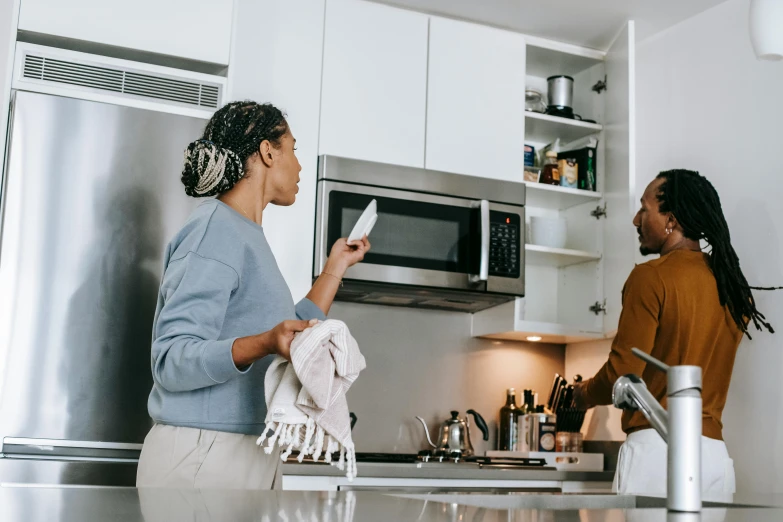 two women talking to each other in a kitchen