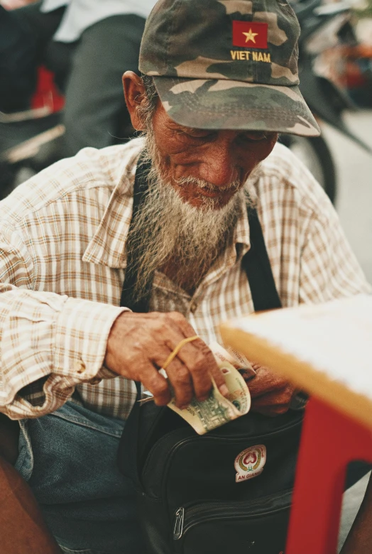 a man with a beard is looking down at money