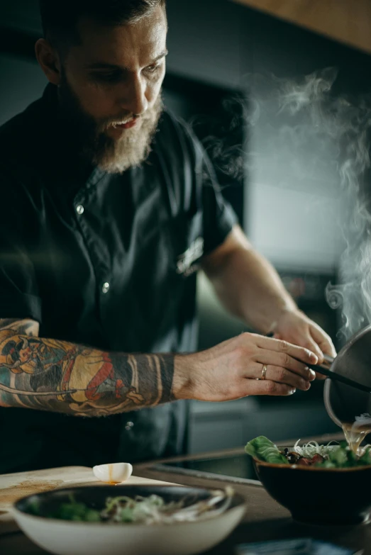 a man cooking in a large pan filled with food