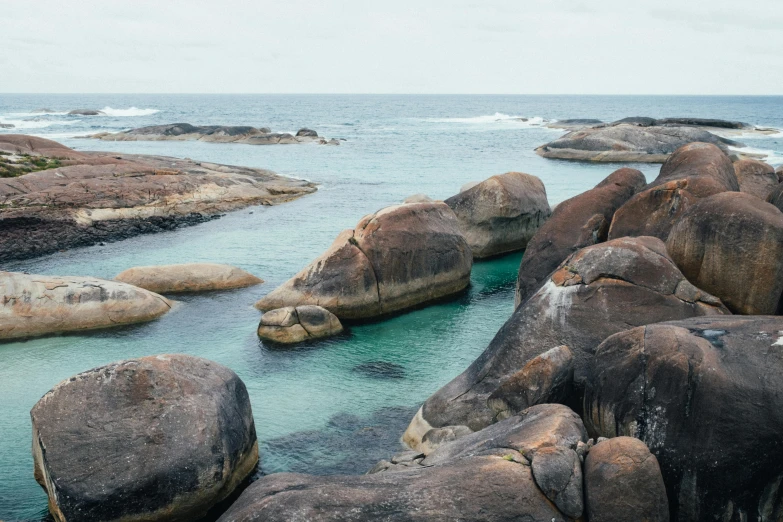 a group of large rocks out in the middle of water