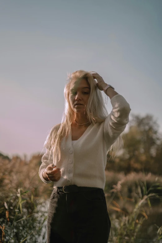 a woman that is standing near some grass