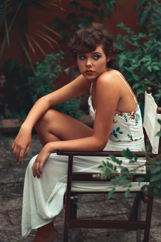 a woman sits down and poses in a chair