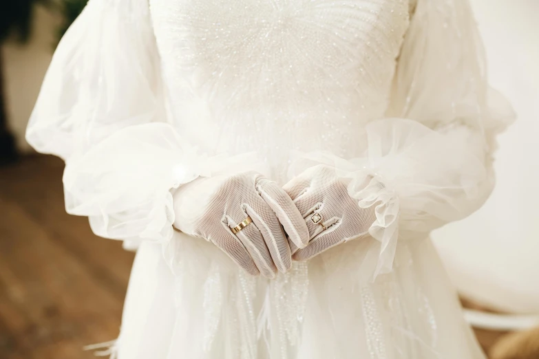 a white dress and hands holding fabric gloves