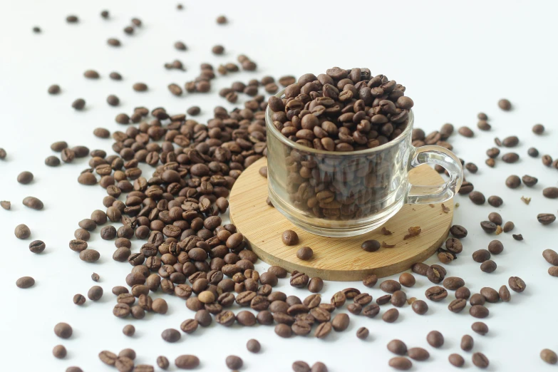 a cup with some coffee beans next to it