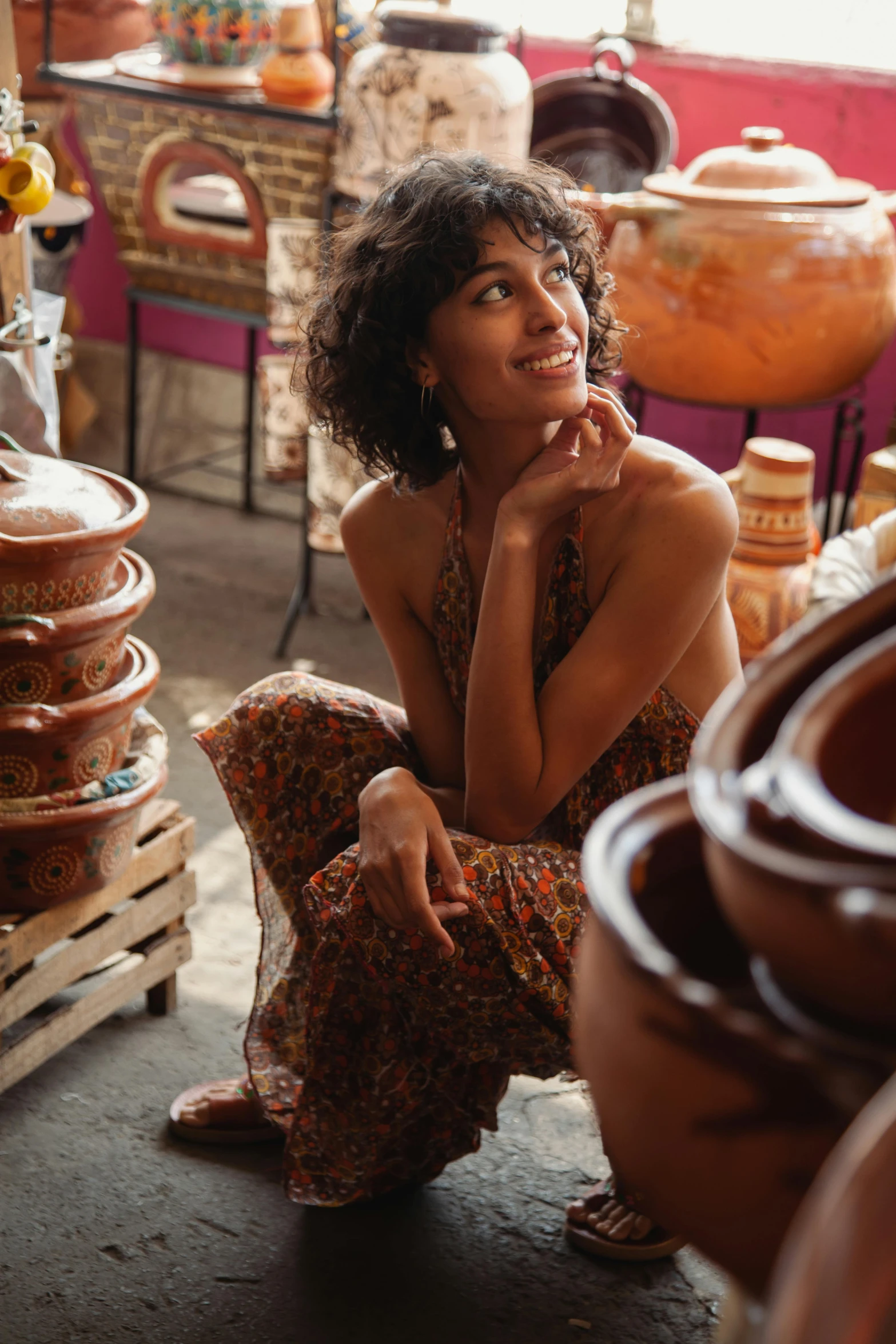 woman kneeling on floor with legs crossed next to pots