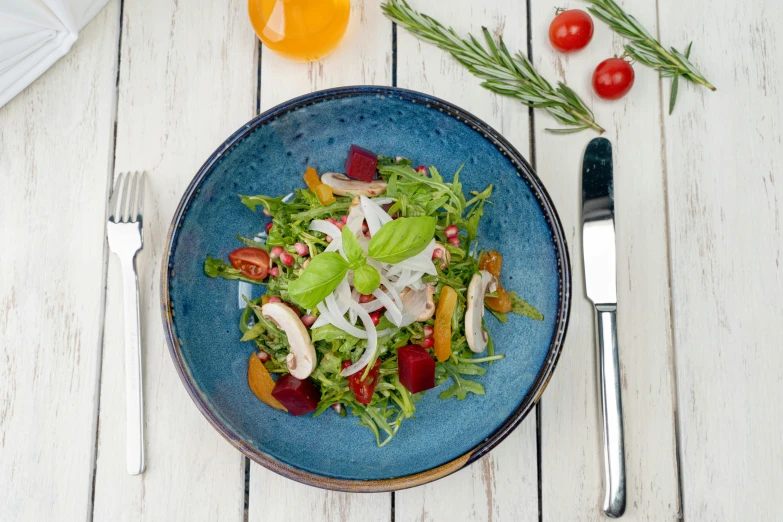 a salad and a fork are sitting on a table