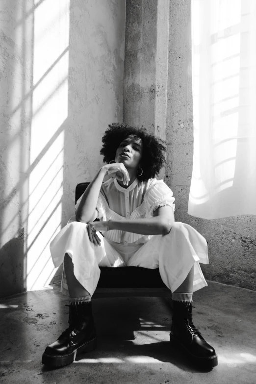 black and white pograph of a woman sitting on a bench in the shade