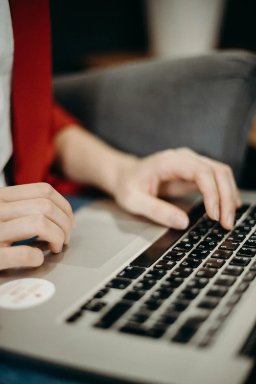 a woman working on her laptop while holding her hand over the screen