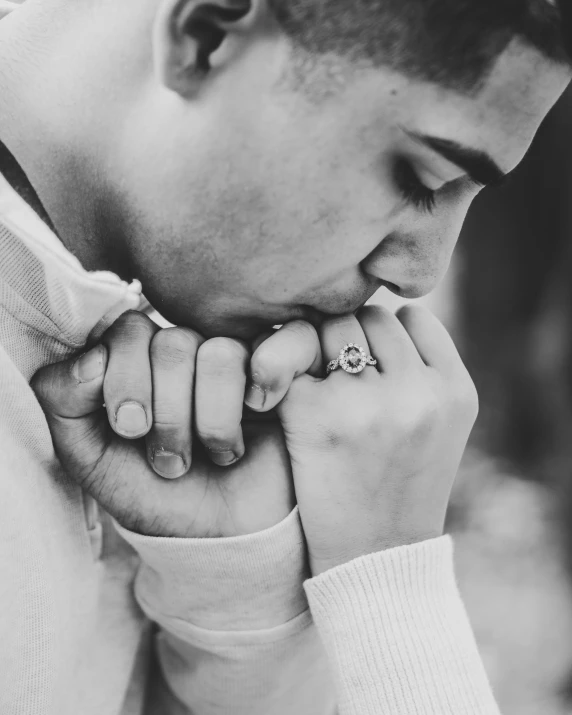 black and white image of man wearing a ring