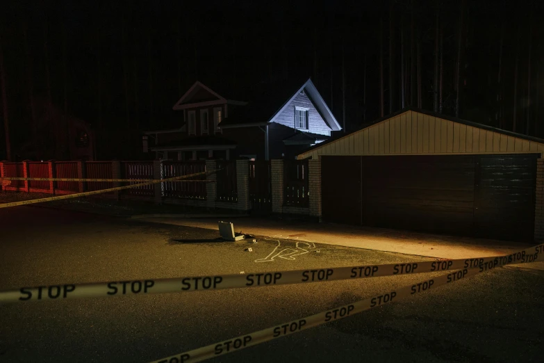 a stop sign is seen next to police tape on the road