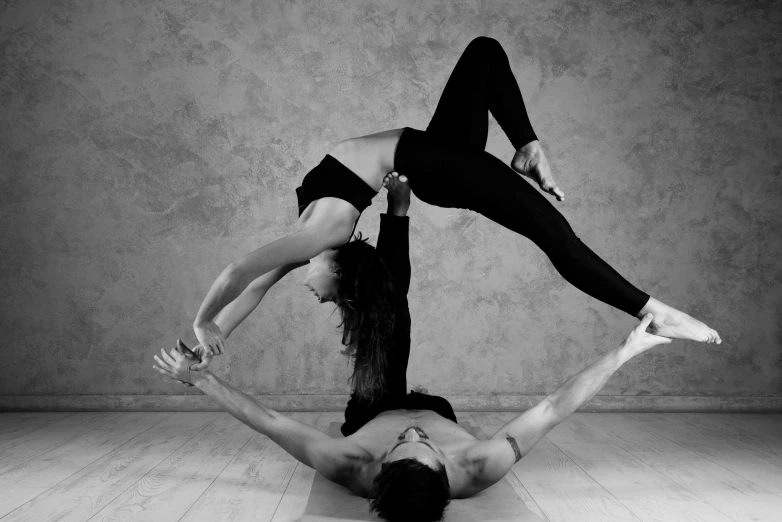 two women are performing aerial moves together on the floor