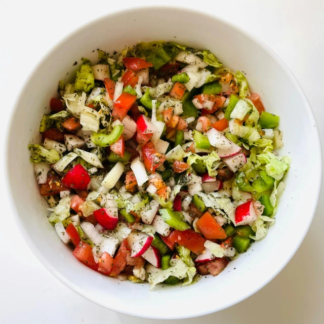 this is a bowl filled with lettuce, onions and tomato