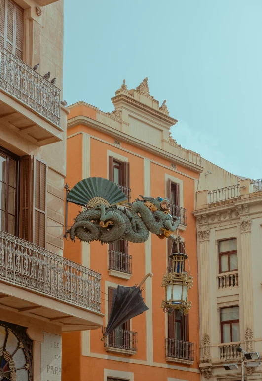 an elaborately designed umbrella hangs over a street in spain