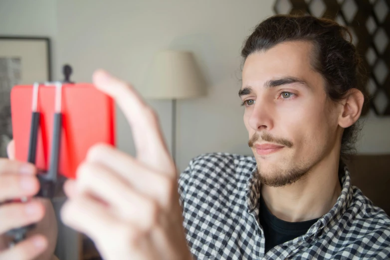 a man holding up a toy item with the finger