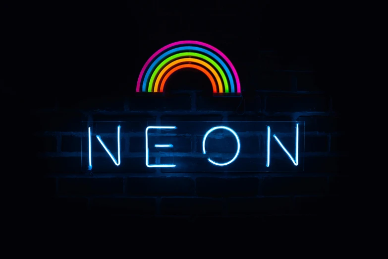 neon sign that reads neon next to a brick wall