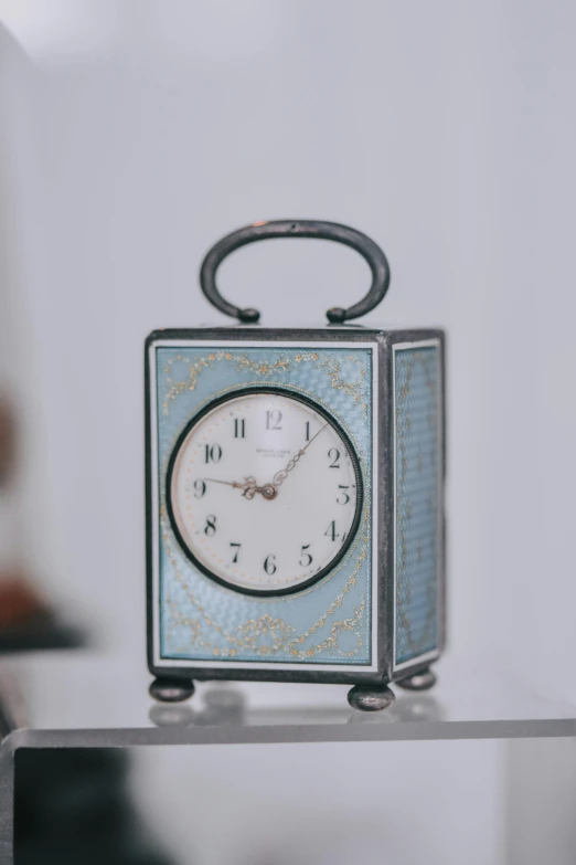 a little square clock sitting on top of a white table