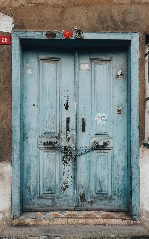 an old house with an old pair of blue doors