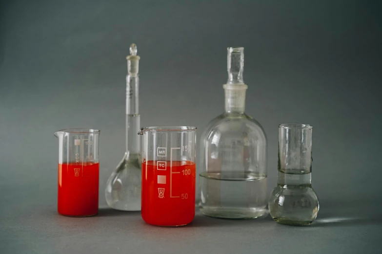 red liquid in beaker glasses and a glass container with beakers