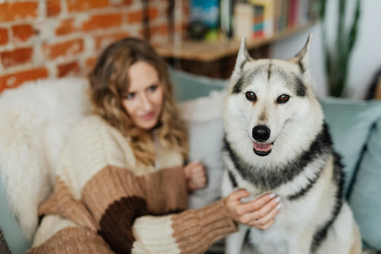 a woman and her dog sitting on the couch