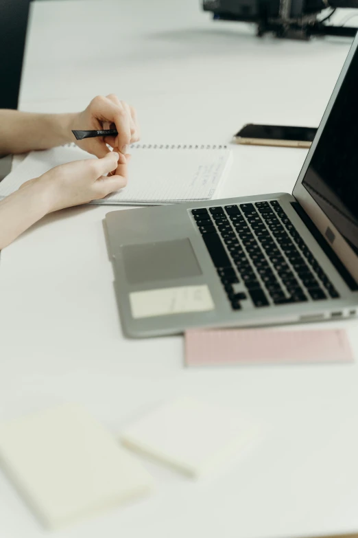 a person is doing paperwork with their laptop