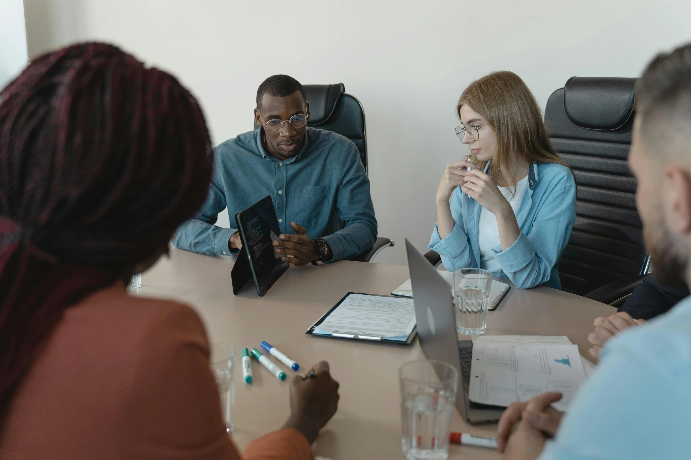 a group of people are talking around a table