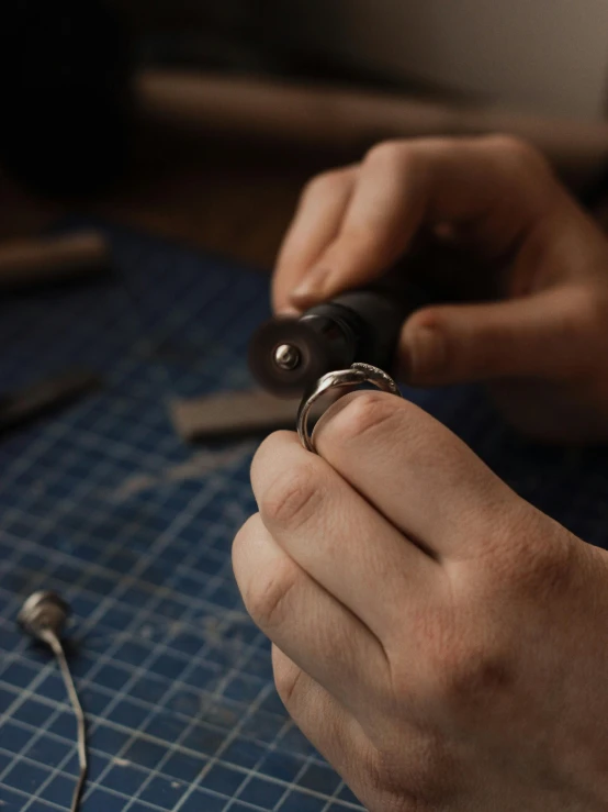 a person is holding a small metal object