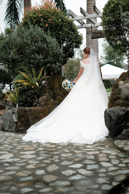 a woman in wedding dress posing by rocks and trees