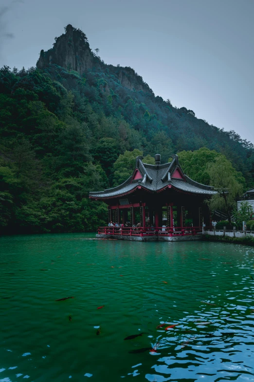 a temple sitting next to a body of water in front of mountains