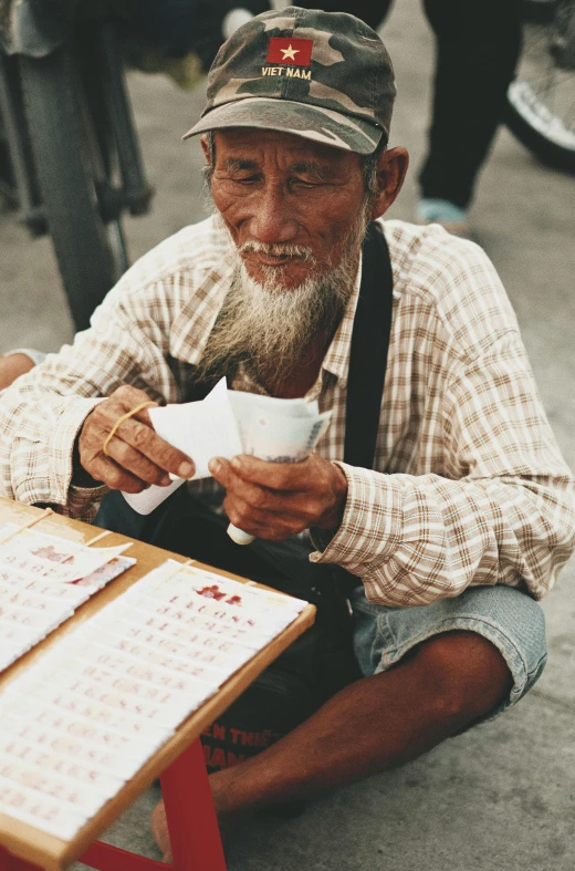 an older man sitting down eating food from a paper