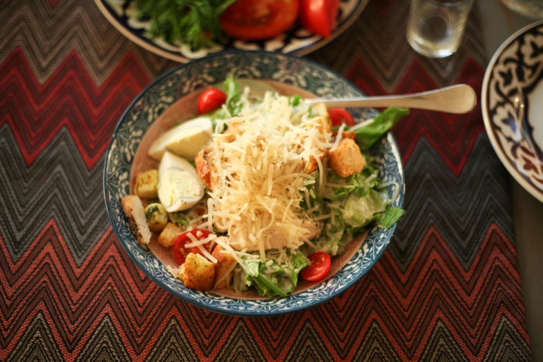 some kind of colorful salad with fruit and parmesan cheese