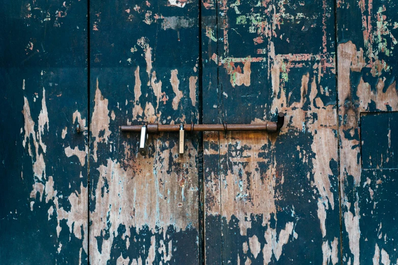 rusted metal handle latch attached to the painted wood