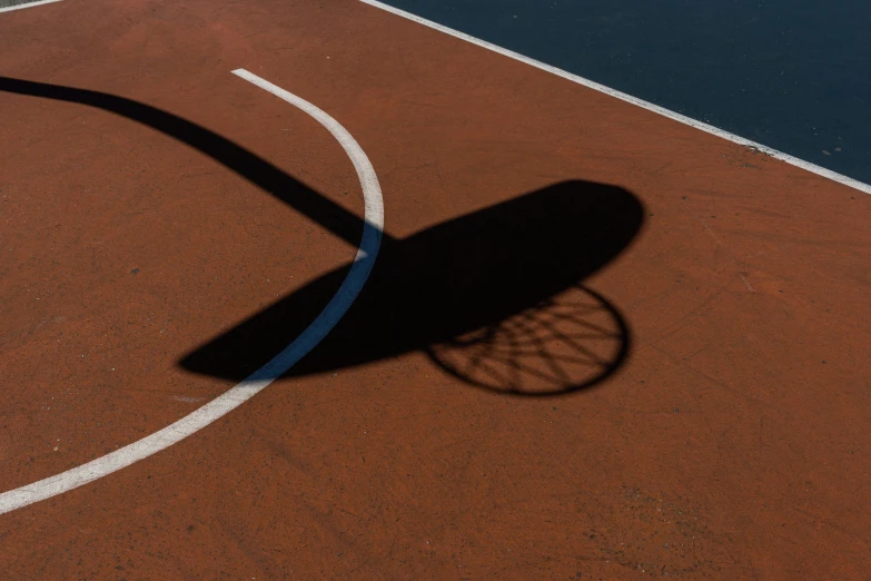 the shadow of a tennis racket and racquet on a court