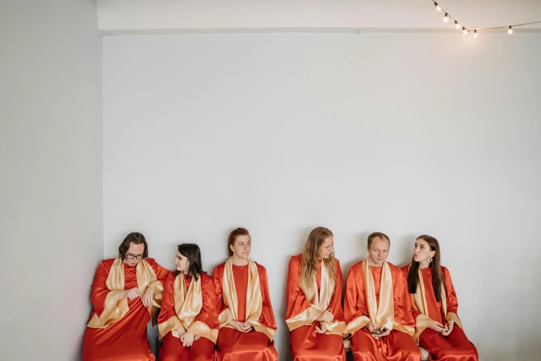 a group of girls wearing red robes sitting next to each other