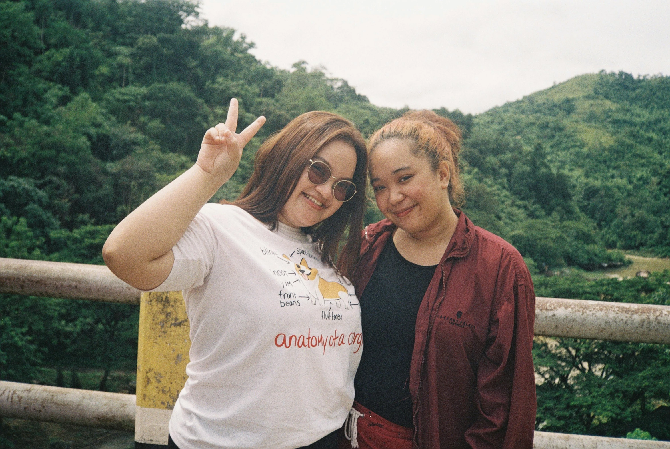 two women posing for the camera on a mountaintop