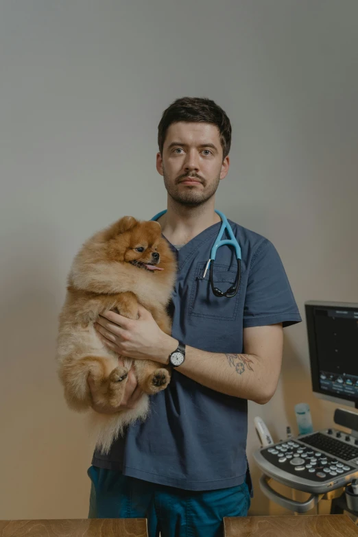 a man in scrubs holds a small dog