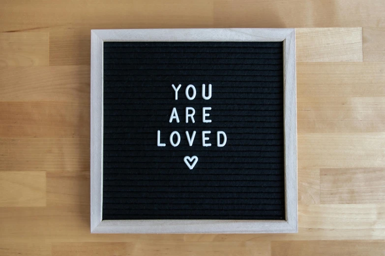 a hand written message in black ink on wooden background