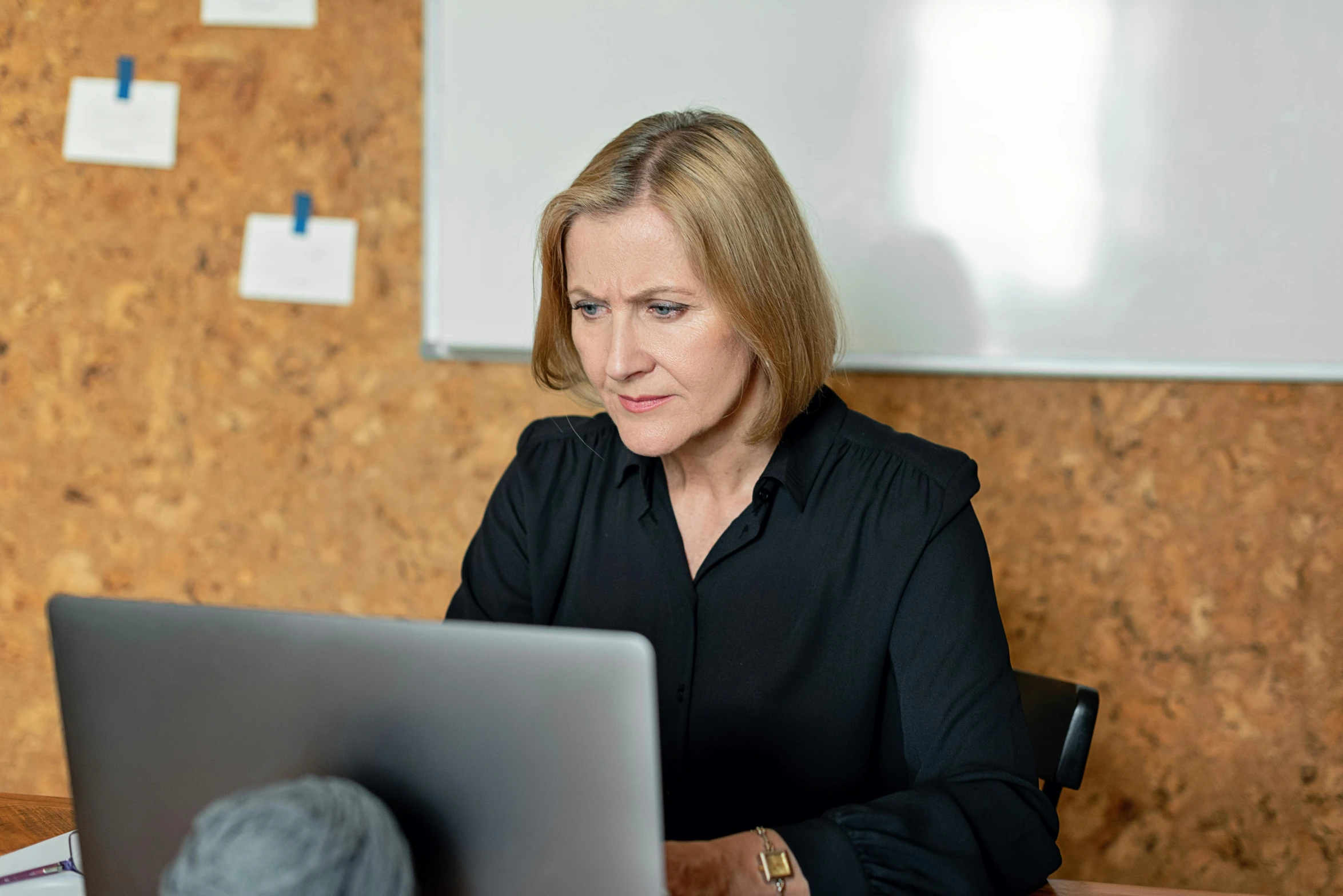 woman at table with laptop computer looking confused