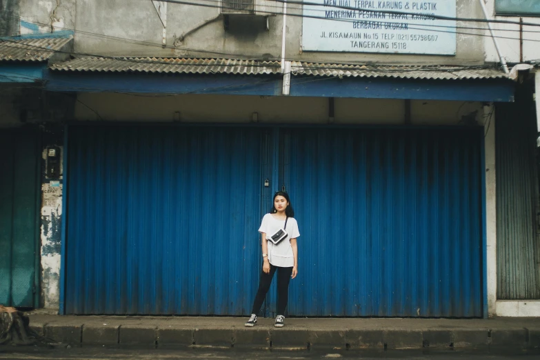 an asian woman standing on a street with her arms in the air